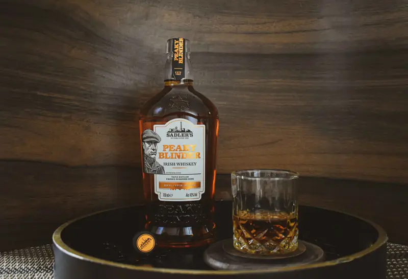 A bottle of bourbon next to a poured glass